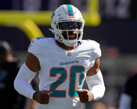 Miami Dolphins linebacker Jordyn Brooks jogs on the field in a white uniform during an NFL game.