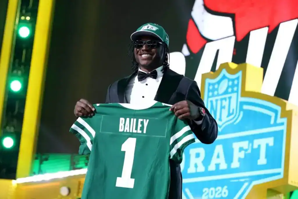Rookie David Bailey poses on stage holding a New York Jets jersey after being selected in the 2026 NFL Draft.
