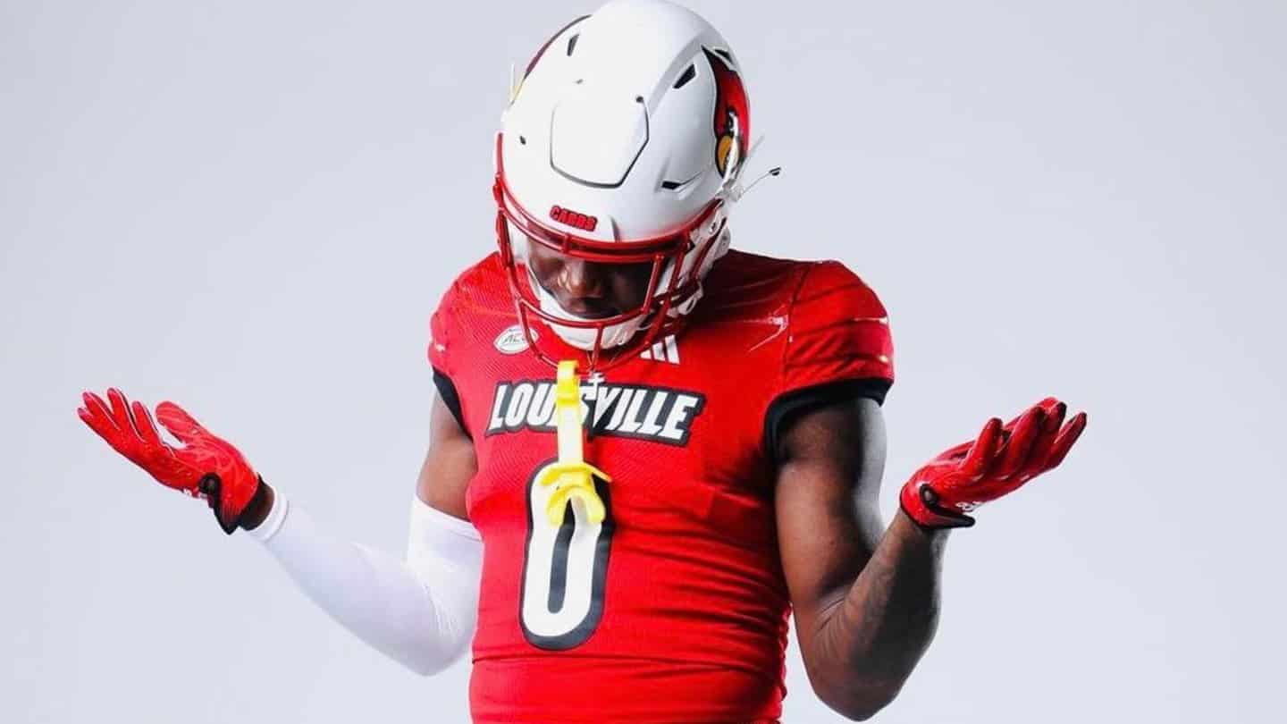 Top-30 visitor Chris Bell in a Louisville red uniform shrugging with hands out, wearing a white helmet.