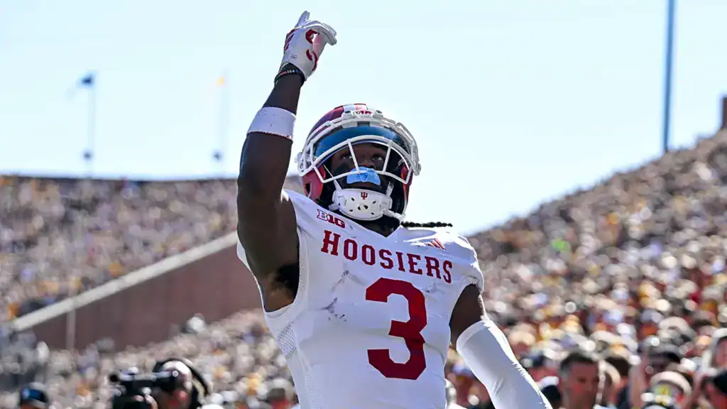 Omar Cooper Jr. draft prospect points upward while wearing Indiana’s white road uniform, celebrating in front of a crowded stadium.