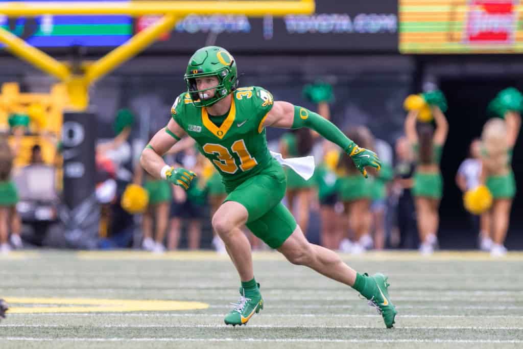 Dillon Thieneman, Oregon defensive back and 2026 NFL Draft prospect, breaks on the ball during a game in a green Ducks uniform.