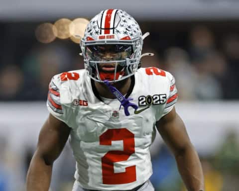 Caleb Downs in Ohio State’s white No. 2 uniform stands ready before the snap during a college football game.