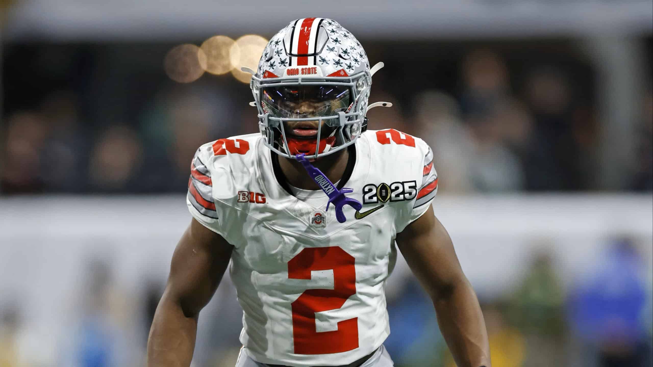Caleb Downs in Ohio State’s white No. 2 uniform stands ready before the snap during a college football game.