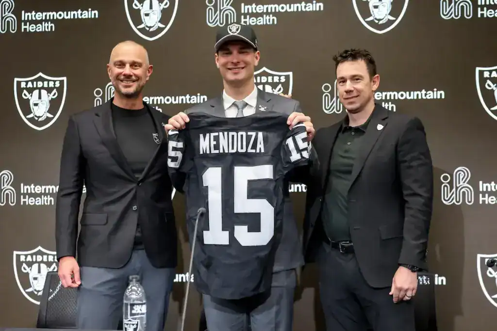 Rookie Fernando Mendoza holds a Las Vegas Raiders jersey during his introductory press conference.