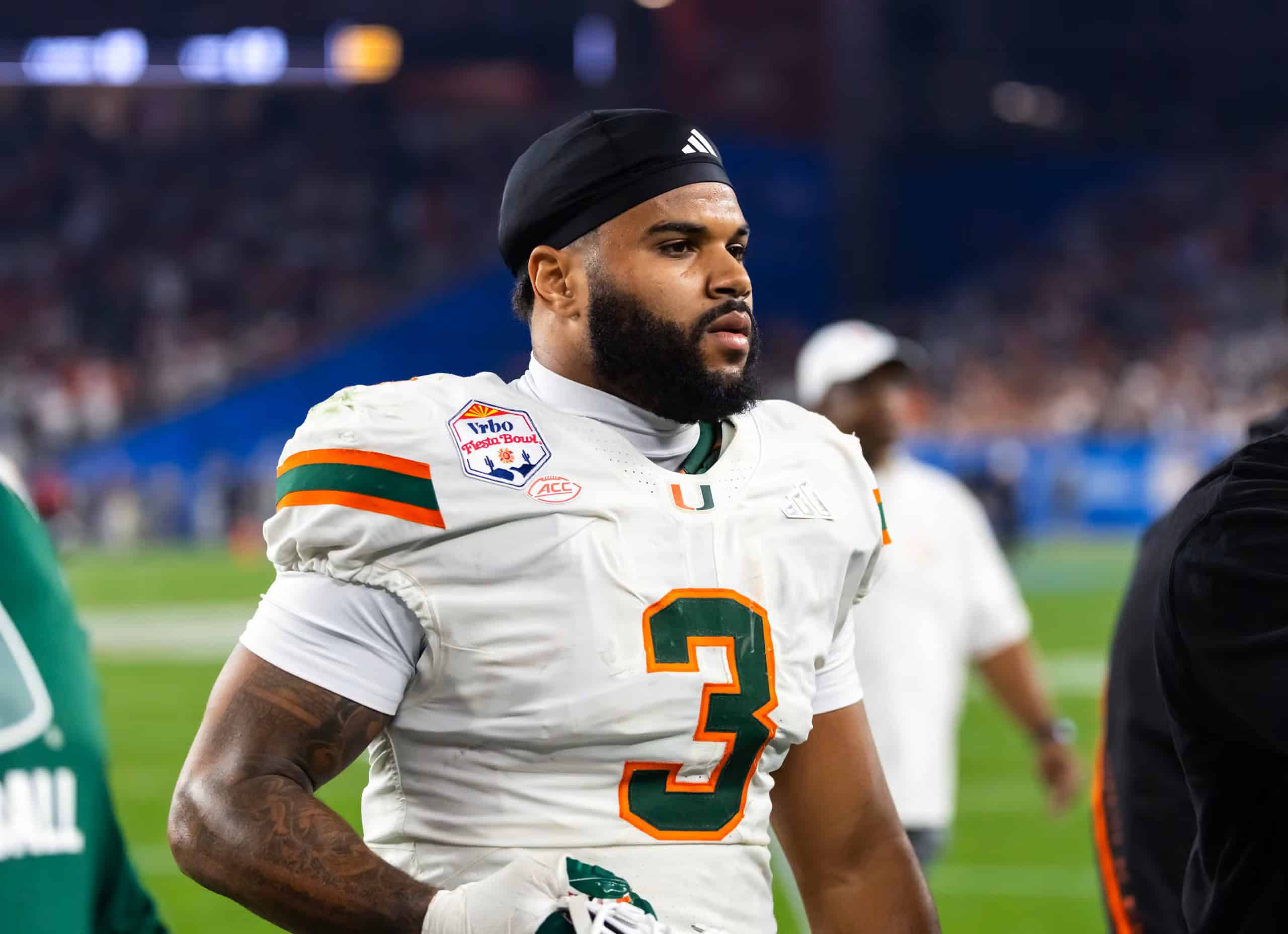 2026 NFL Draft prospect Akheem Mesidor walks on the sideline in a white Miami Hurricanes uniform after the game.