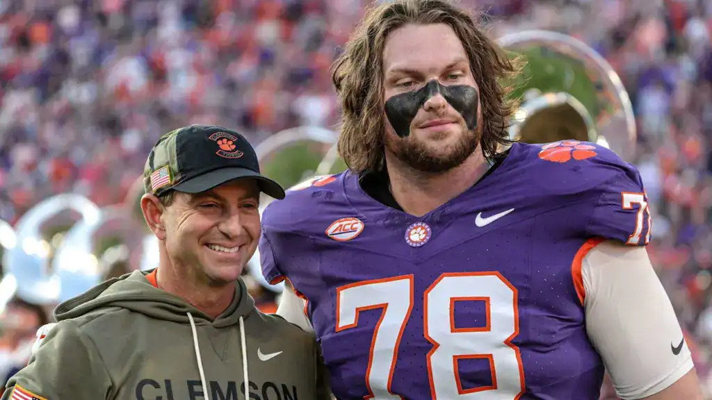 Blake Miller draft prospect stands beside Clemson head coach Dabo Swinney after a game, wearing No. 78 in a purple Tigers jersey.