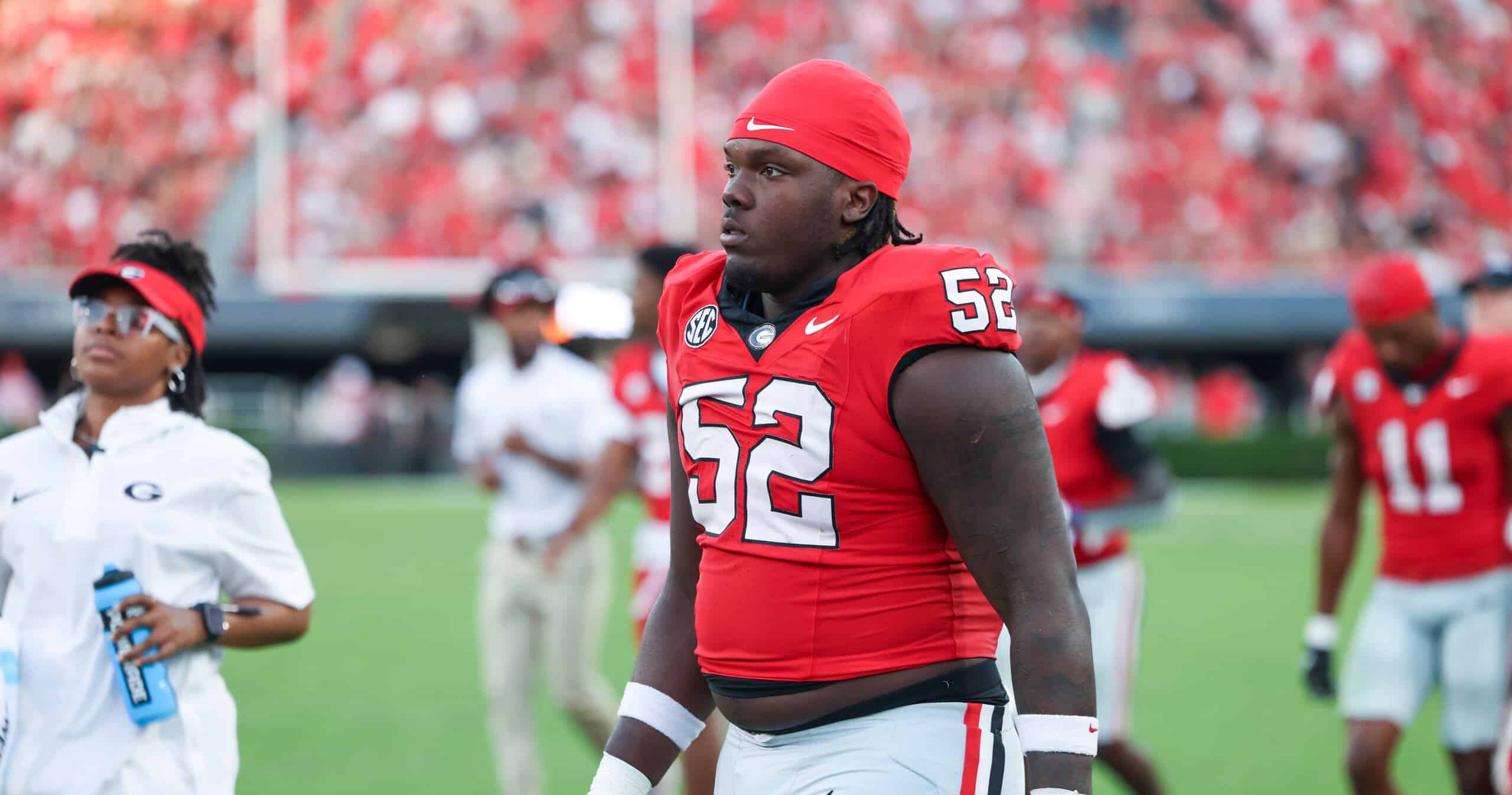 Christen Miller, Georgia draft prospect, walking the sideline in a red Bulldogs uniform before the game.