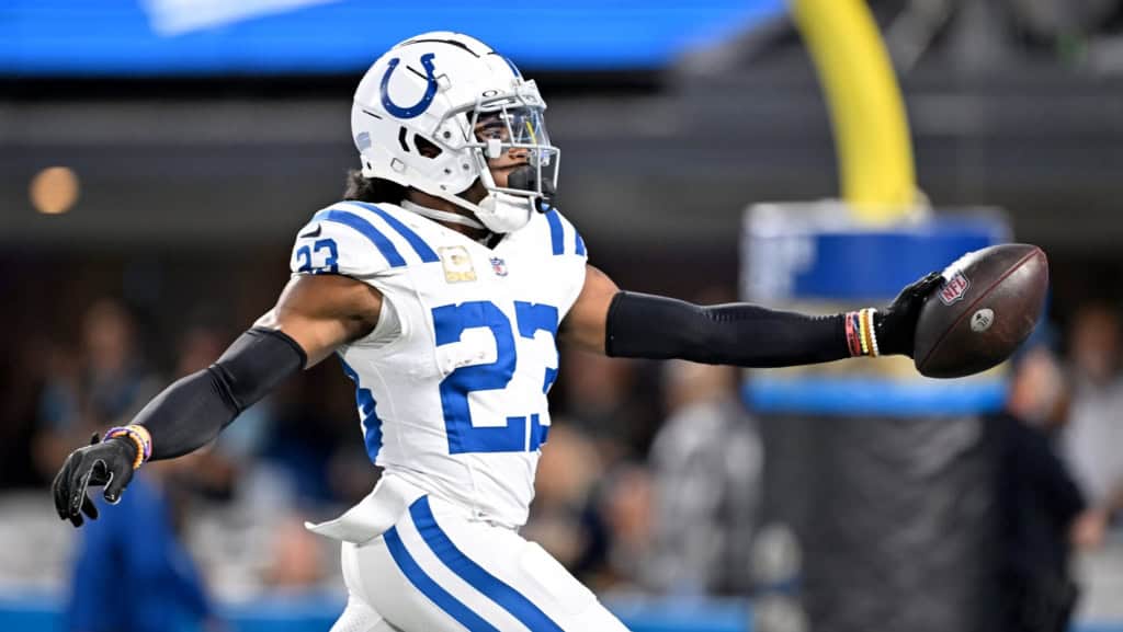 Kenny Moore II runs with the football after a turnover for the Indianapolis Colts, wearing a white uniform with the goalpost in the background.