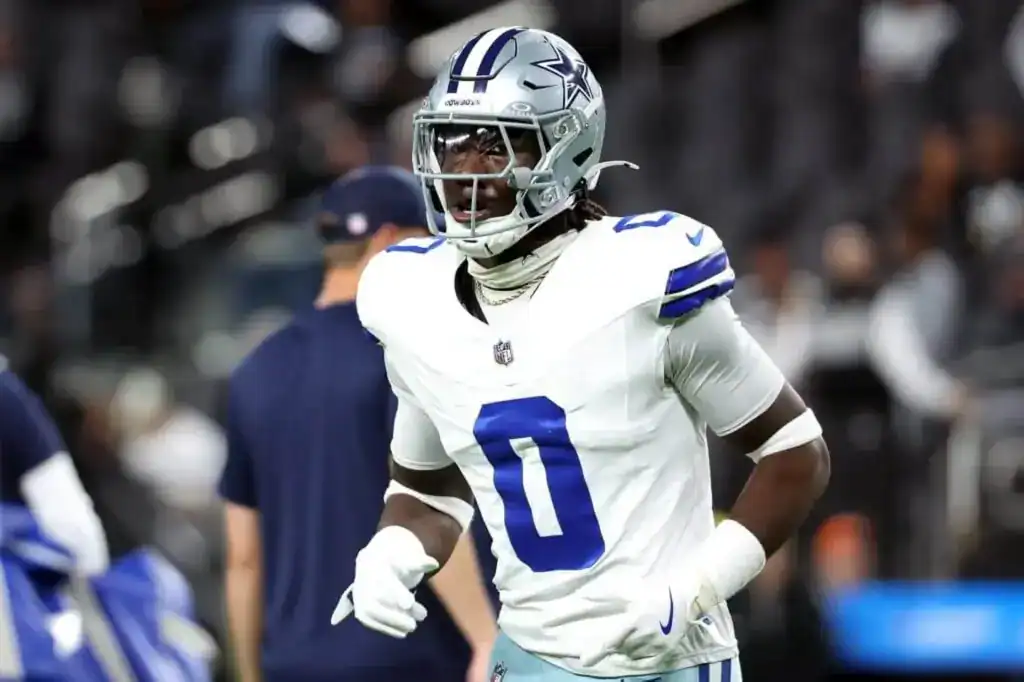 Dallas Cowboys linebacker DeMarvion Overshown warms up in a white road uniform before a game, wearing No. 0 and a silver helmet on the field.