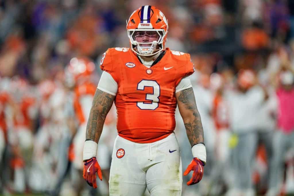 T.J. Parker draft prospect celebrates in Clemson’s orange uniform during a game, wearing No. 3 with a packed stadium blurred in the background.