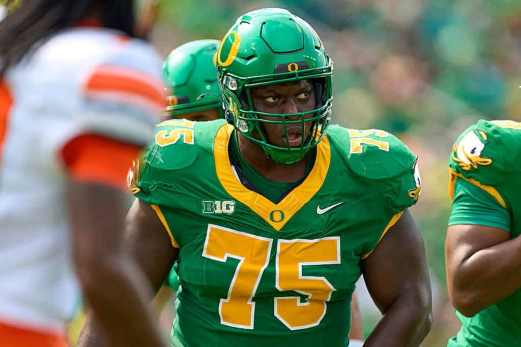 Emmanuel Pregnon, Oregon draft prospect, set at the line in a green Ducks uniform during game action.