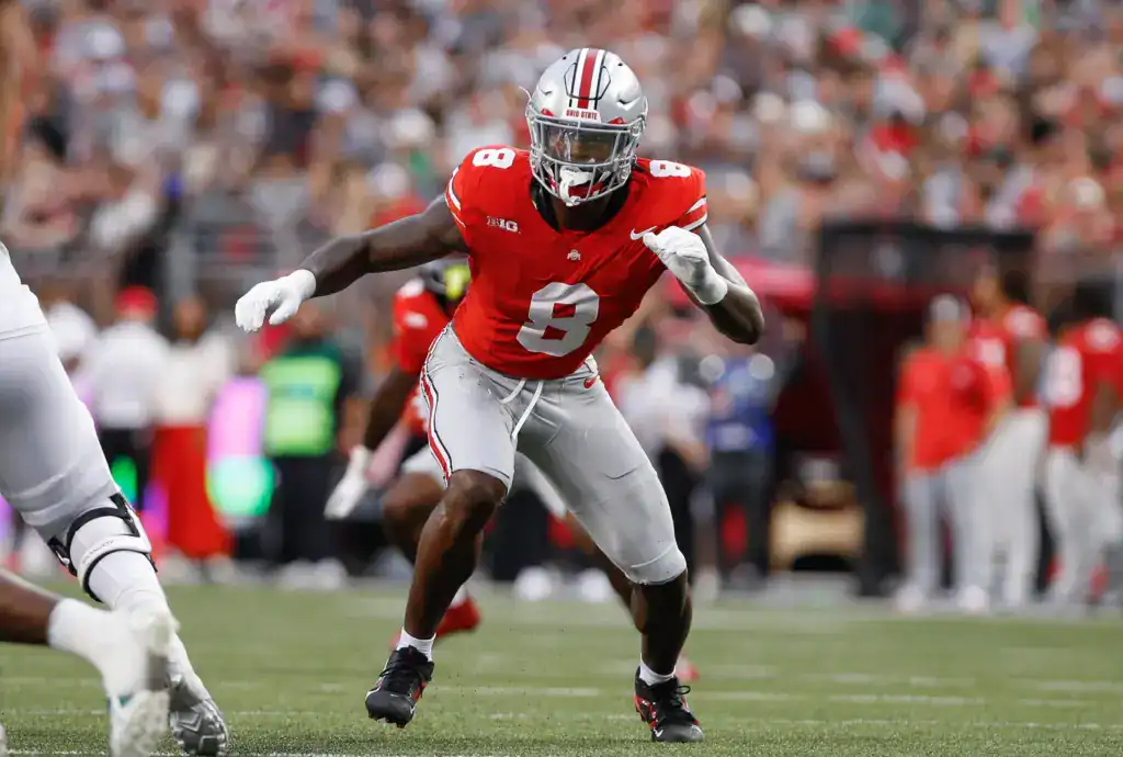Arvell Reese of Ohio State in a red No. 8 uniform exploding forward before the snap during game action.