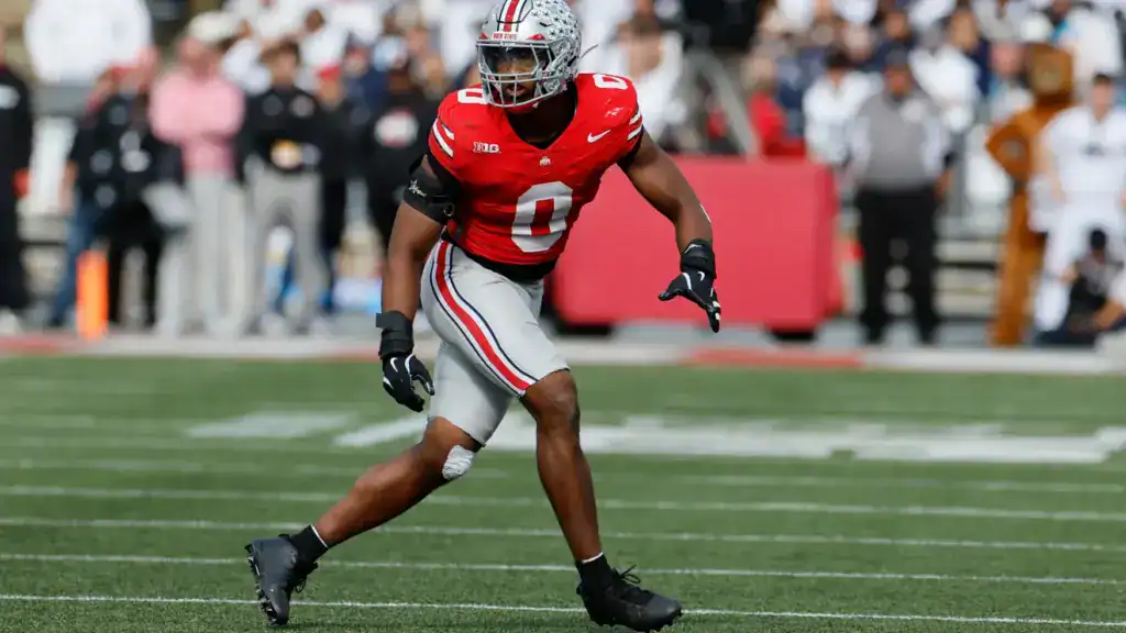 Sonny Styles in Ohio State’s red uniform breaks forward on the field during game action.