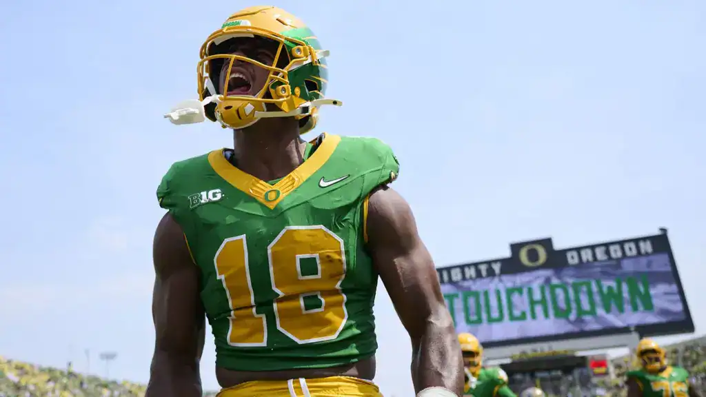 Kenyon Sadiq, Oregon tight end and 2026 NFL Draft prospect, celebrates in the end zone while holding the football in a USC game.