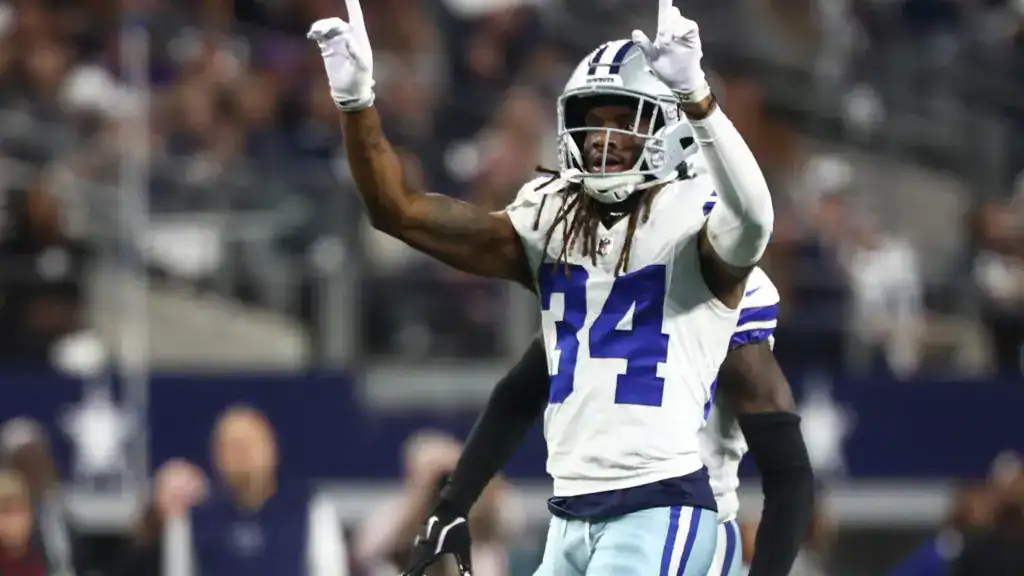 Shavon Revel Jr. raises both hands after a big play in his Dallas Cowboys No. 34 jersey.
