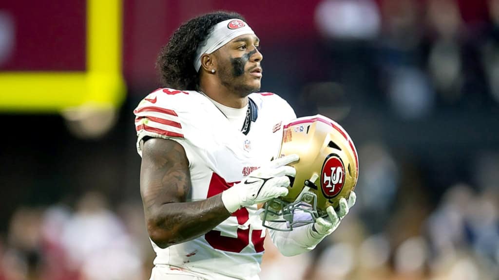Dee Winters linebacker holding a San Francisco 49ers helmet before a game.