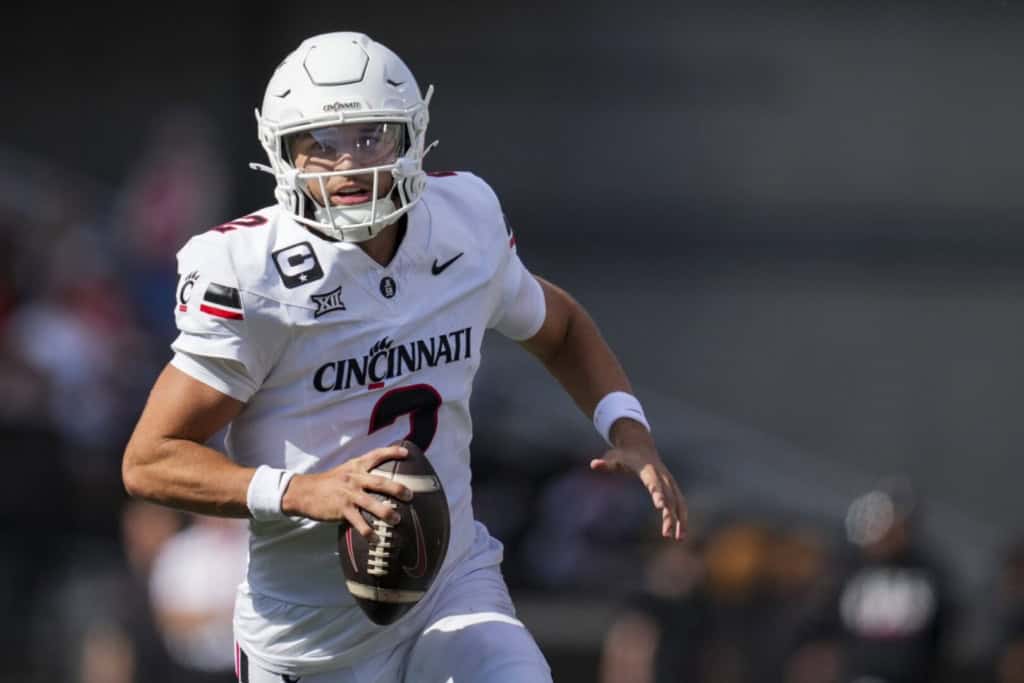 Brendan Sorsby scrambling with the football in a white Cincinnati Bearcats uniform