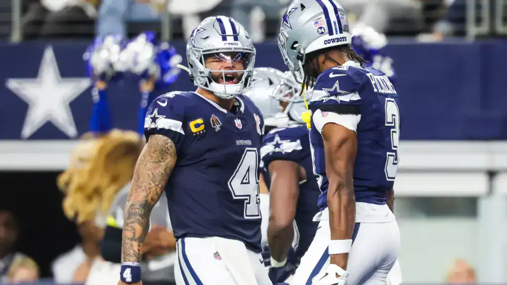 Dallas Cowboys quarterback Dak Prescott celebrates on the field with wide receiver George Pickens during a game at AT&T Stadium.