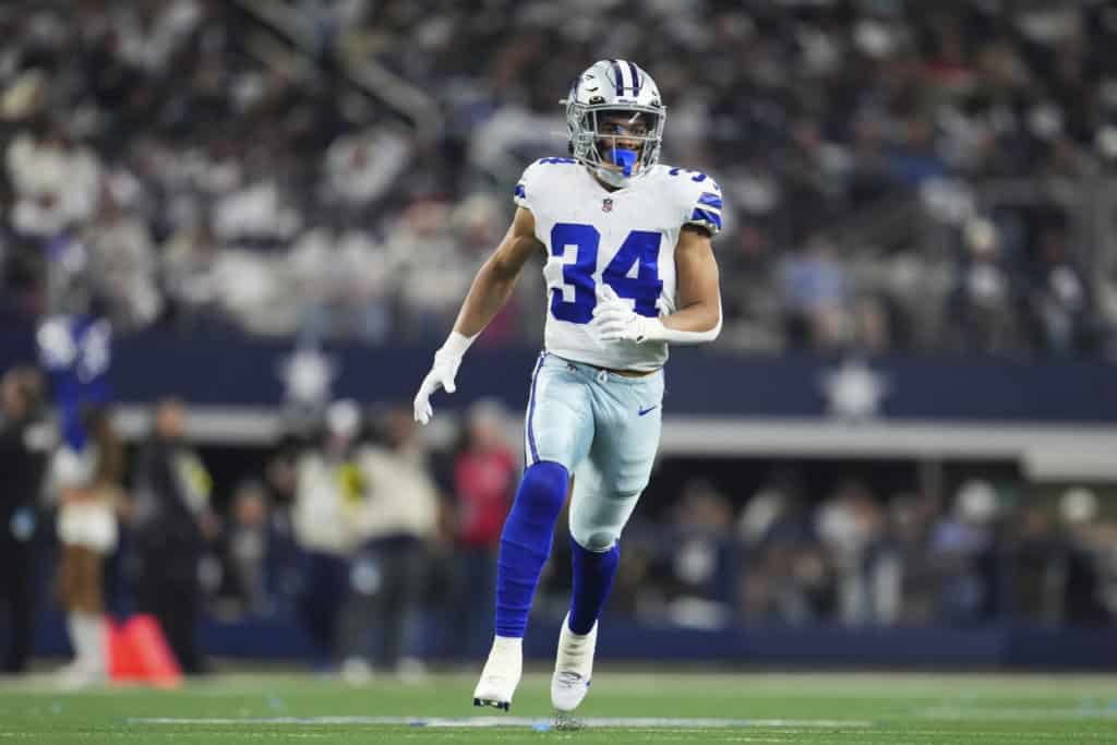 Malik Davis runs across the field for the Dallas Cowboys during an NFL game.