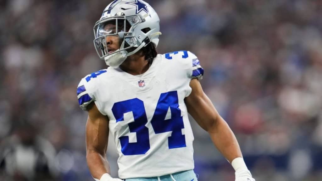 Malik Davis looks upfield in his Dallas Cowboys No. 34 uniform during warmups.