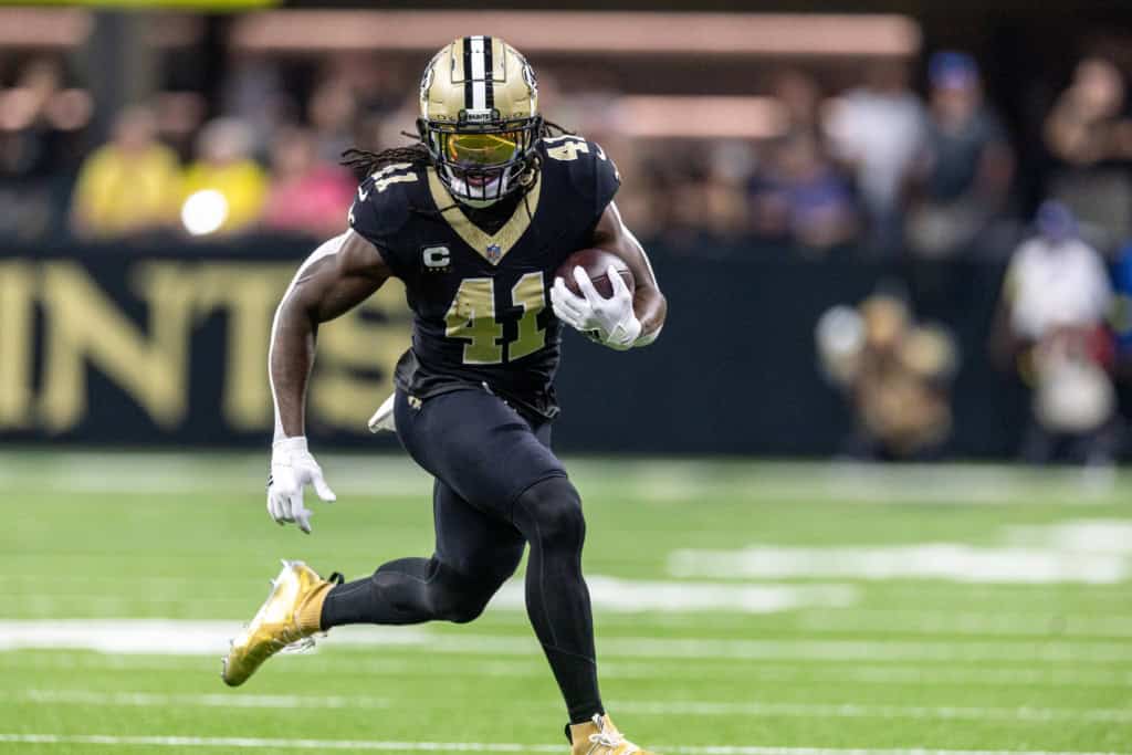 Alvin Kamara runs with the football for New Orleans while Cowboys rumors raise questions about veteran backfield help