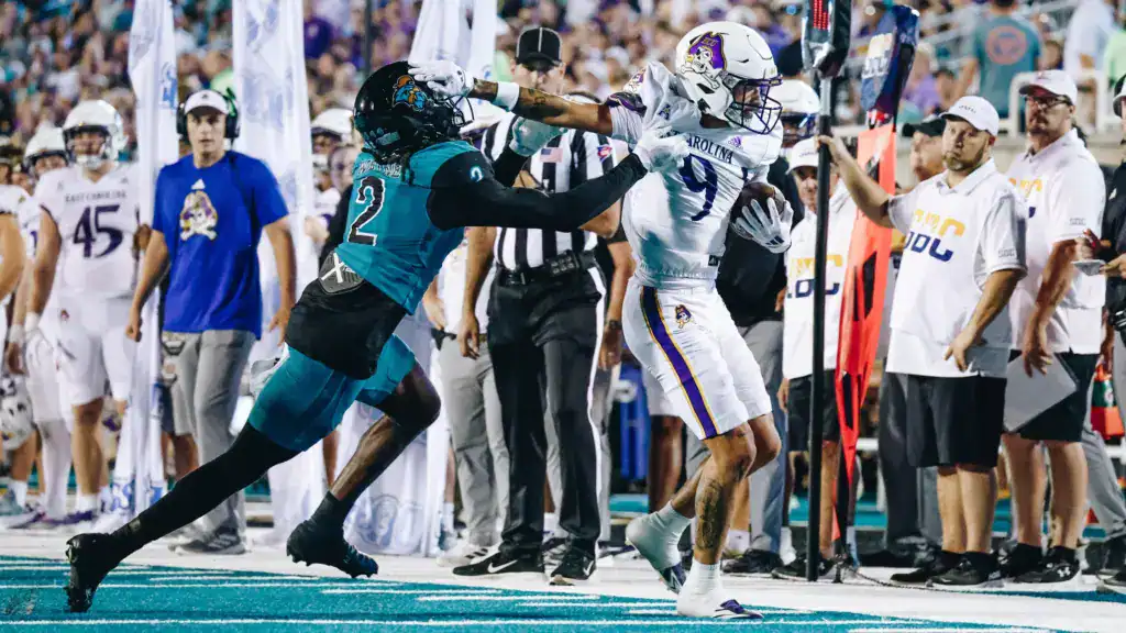 Anthony Smith stiff-arms a Coastal Carolina defender while making a catch near the sideline for East Carolina.