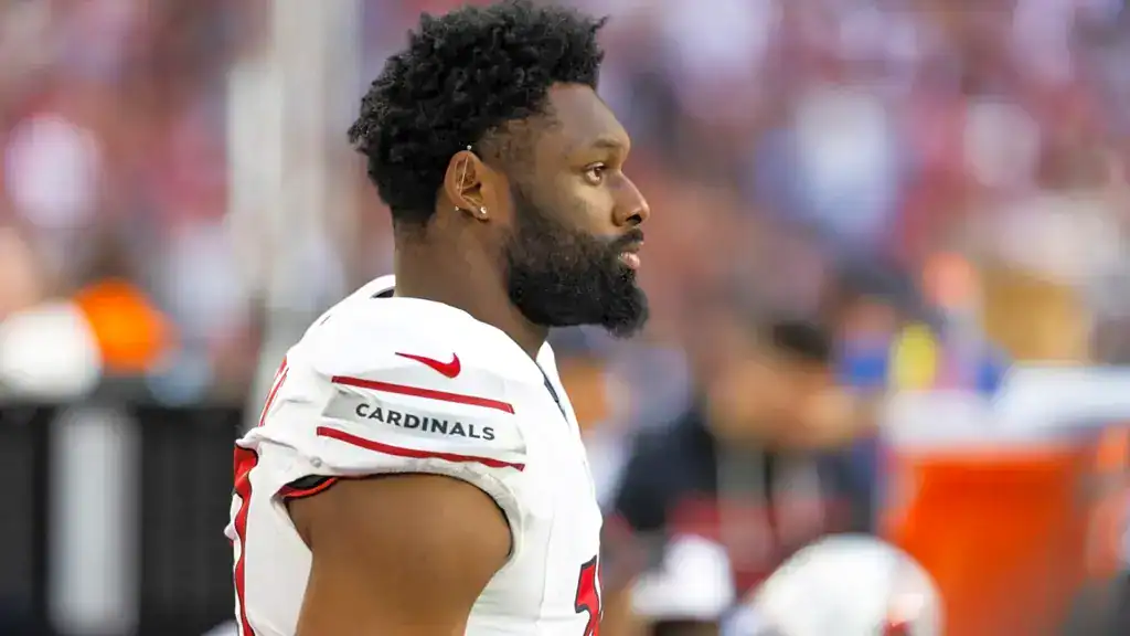 Josh Sweat stands on the sideline in an Arizona Cardinals uniform during game action.