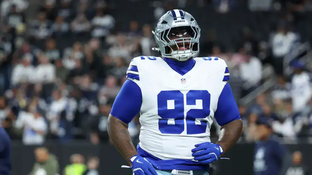 Quinnen Williams stands on the field in his Dallas Cowboys uniform during a Micah Parsons trade recap discussion.