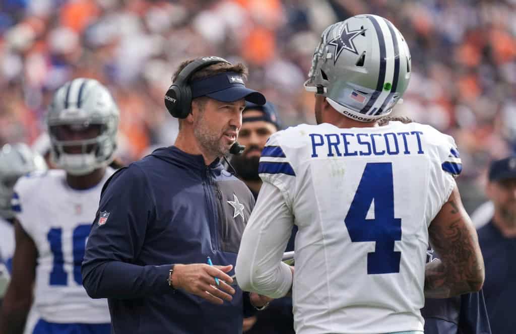 Dak Prescott meets with a Cowboys coach on the sideline as Dallas searches for less offensive errors.