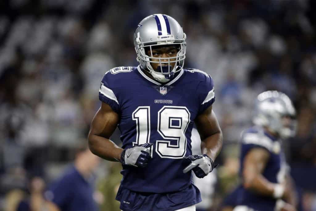 Former Dallas Cowboys wide reciever Amari Cooper running off the field wearing a navy blue Cowboys uniform.