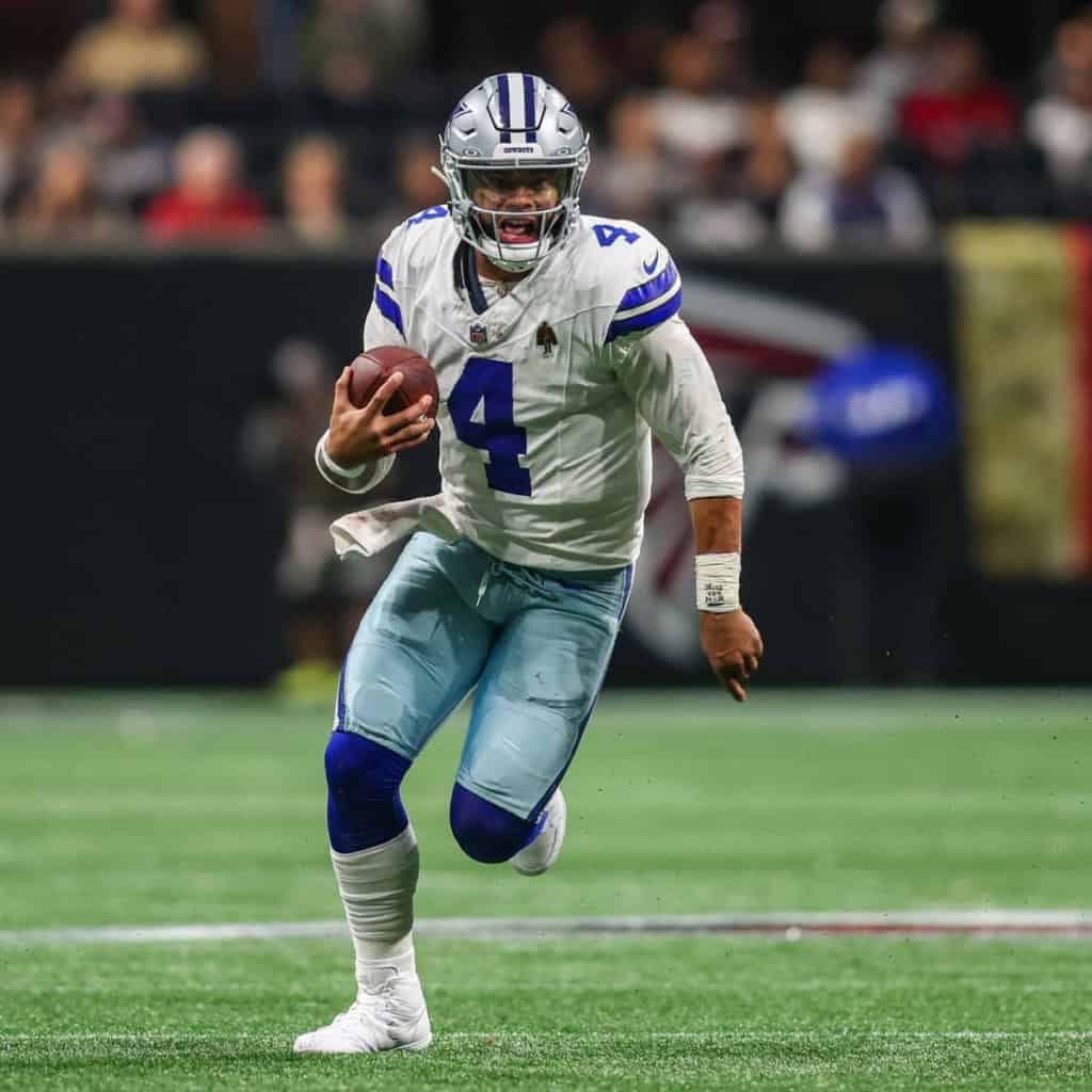 Dak Prescott scrambling with the football as one of the key names in the debate over PFF’s Cowboys offense list. 