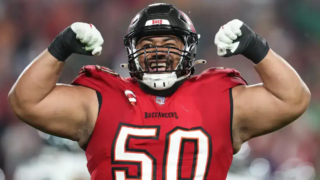 Tampa Bay Buccaneers defensive tackle Vita Vea flexes both arms while celebrating in his red Buccaneers uniform.