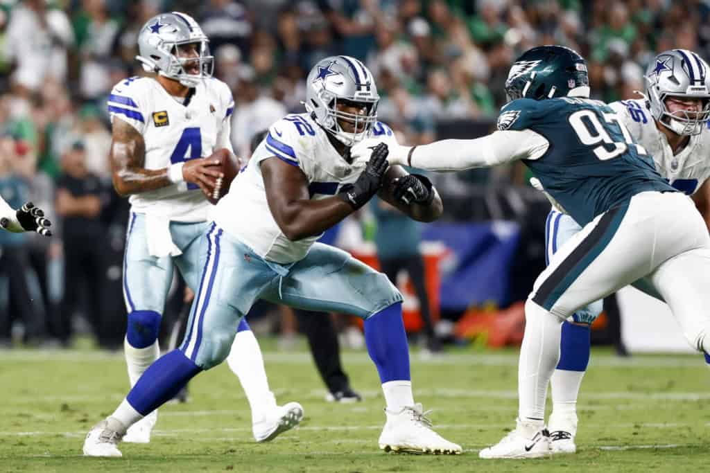 Cowboys offensive lineman Tyler Booker blocks Philadelphia Eagles defensive tackle Jalen Carter as Dak Prescott looks to pass.
