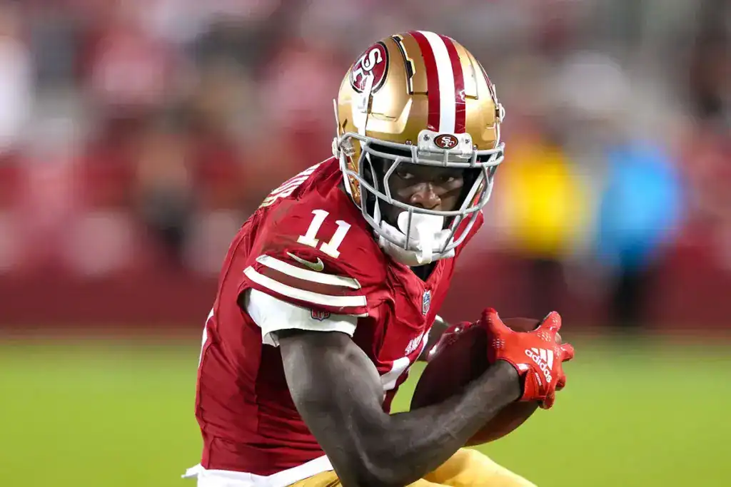 Brandon Aiyuk to Dallas Sounds Good Until The Headache Takes Over San Francisco 49ers wide receiver Brandon Aiyuk carries the football while looking upfield during a game.