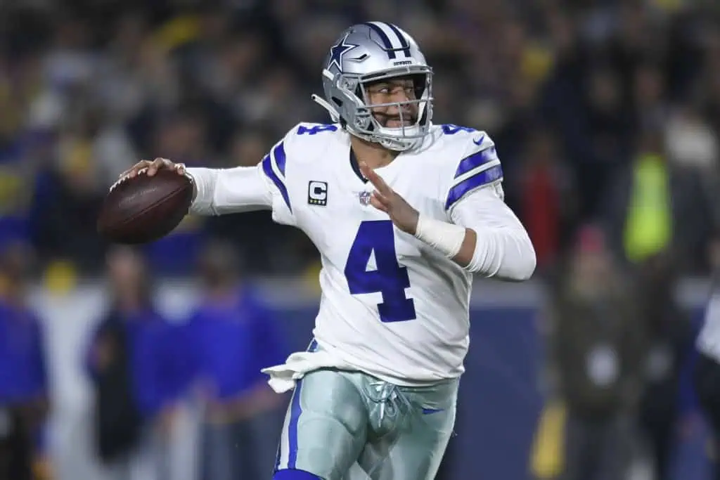 Dallas Cowboys quarterback Dak Prescott scrambles as he is about to make a pass. 