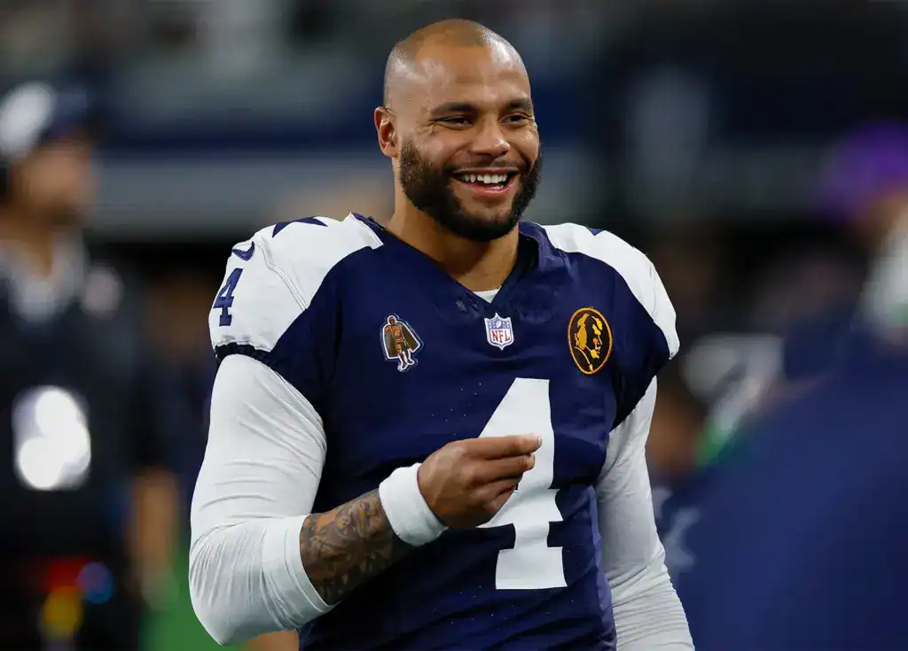 Quinnen Williams Deal Proves Dallas Can Pay Pickens in 26' Dak Prescott smiles in his Cowboys blue and white throwback uniform.