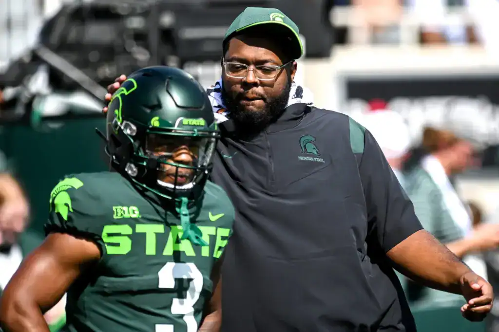 A Michigan State defensive coach BT Jordan, now with the Cowboys, works with a player on the sideline, tying into the Cowboys’ new defensive coaching influence and pass-rush development.