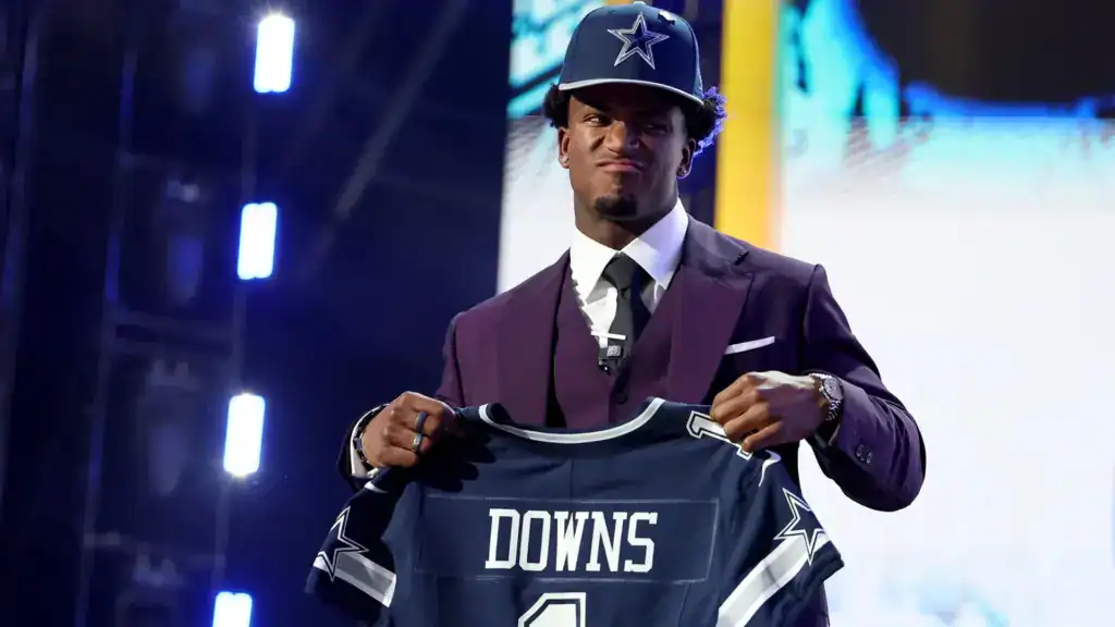 Caleb Downs holds up his Dallas Cowboys jersey after being selected in the NFL Draft.