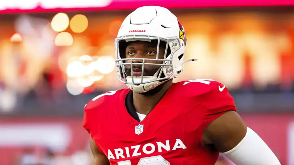 Arizona Cardinals defensive lineman Calais Campbell stands on the field in his red Cardinals uniform and white helmet.