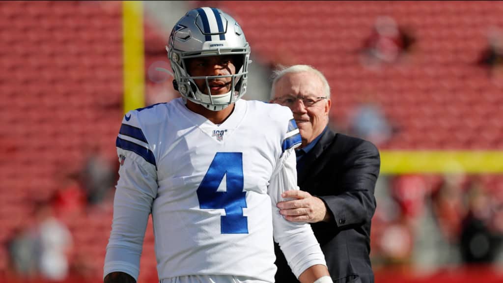 Will Cowboys Nostalgia Bring Shedeur Sanders to Dallas? Dak Prescott walks on the field in a Dallas Cowboys uniform with Jerry Jones behind him before a game.