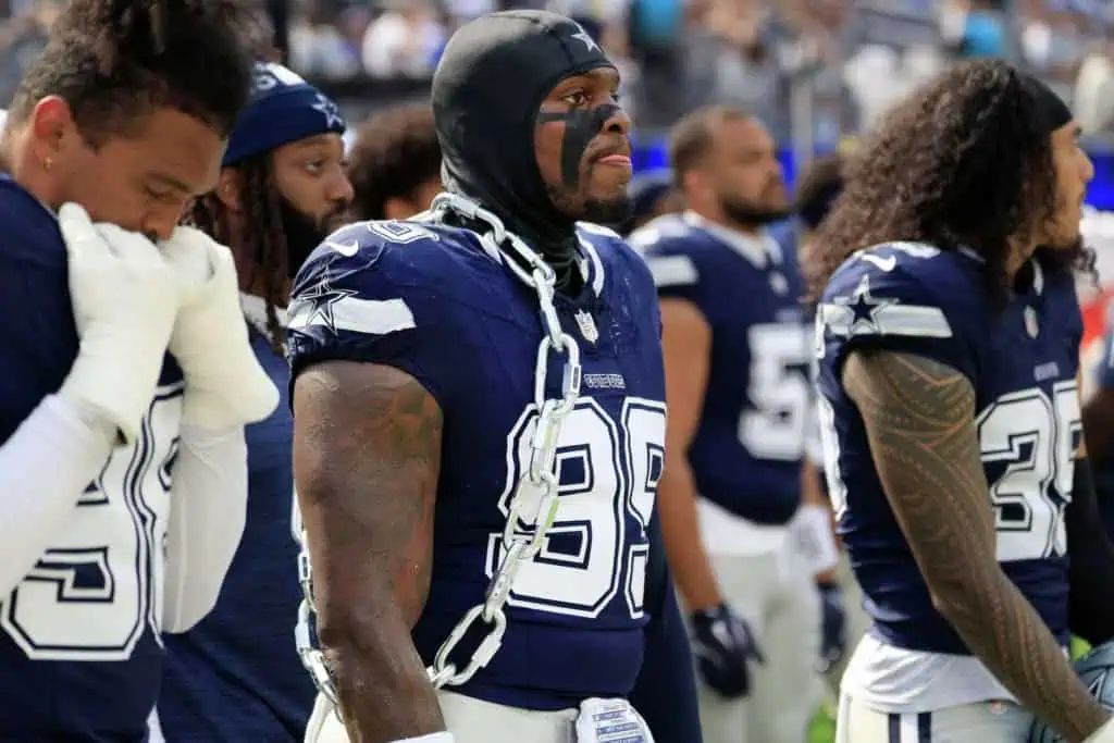 Dallas Cowboys defensive lineman Perrion Winfrey (90) wears a weighted chain during pregame warmups with teammates.