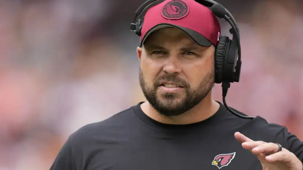 Dallas Cowboys offensive coordinator, and former Arizona Cardinals offensive line coach, Klayton Adams wearing a headset on the sideline during an NFL game.