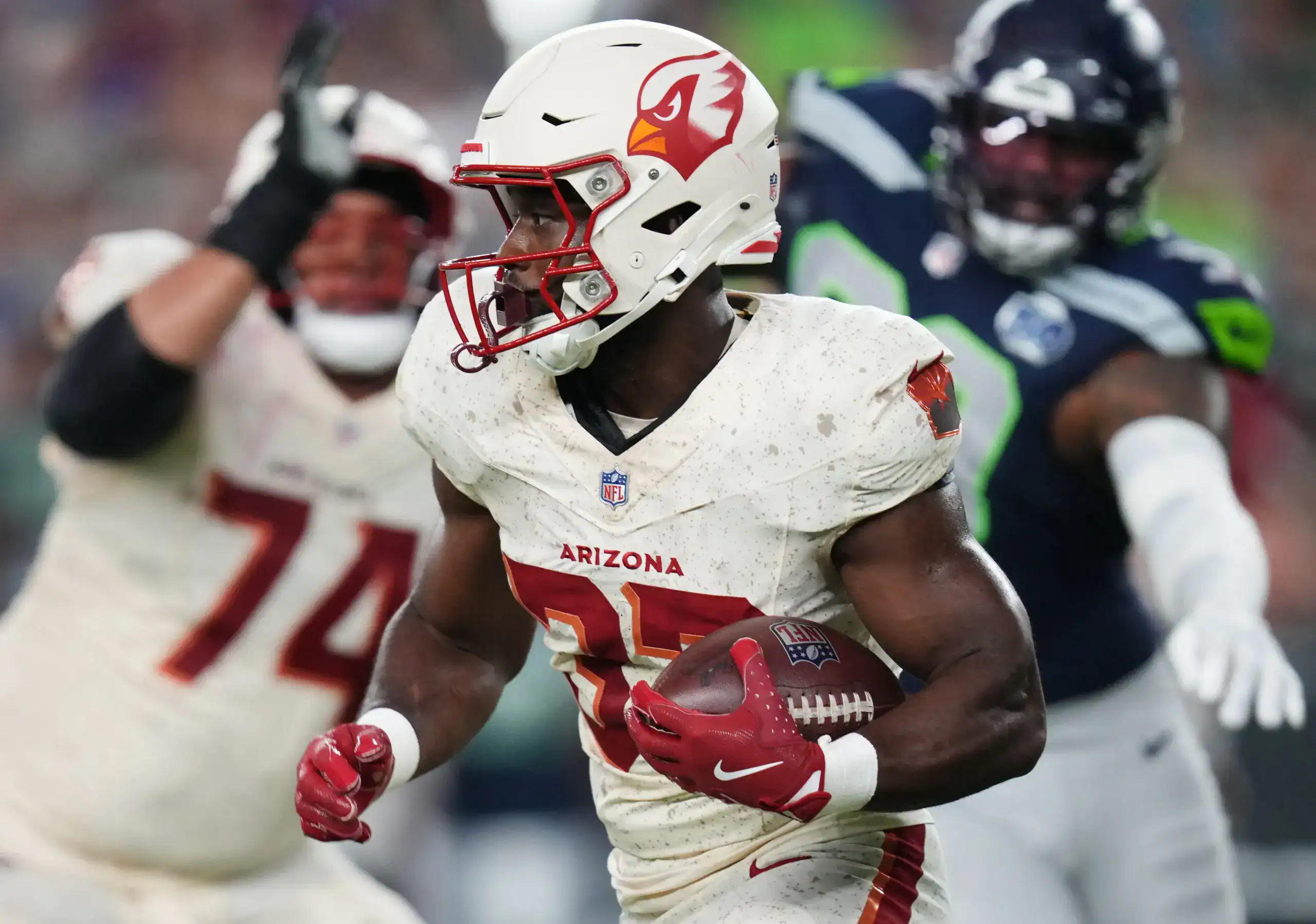 Arizona Cardinals running back Emari Demercado runs with the football while breaking away from a Seattle Seahawks defender.