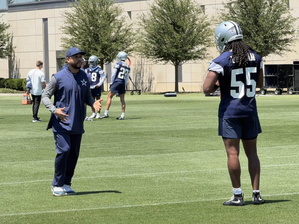 Dallas Cowboys linebacker Jaishawn Barham talks with defensive coordinator Christian Parker during training camp practice.