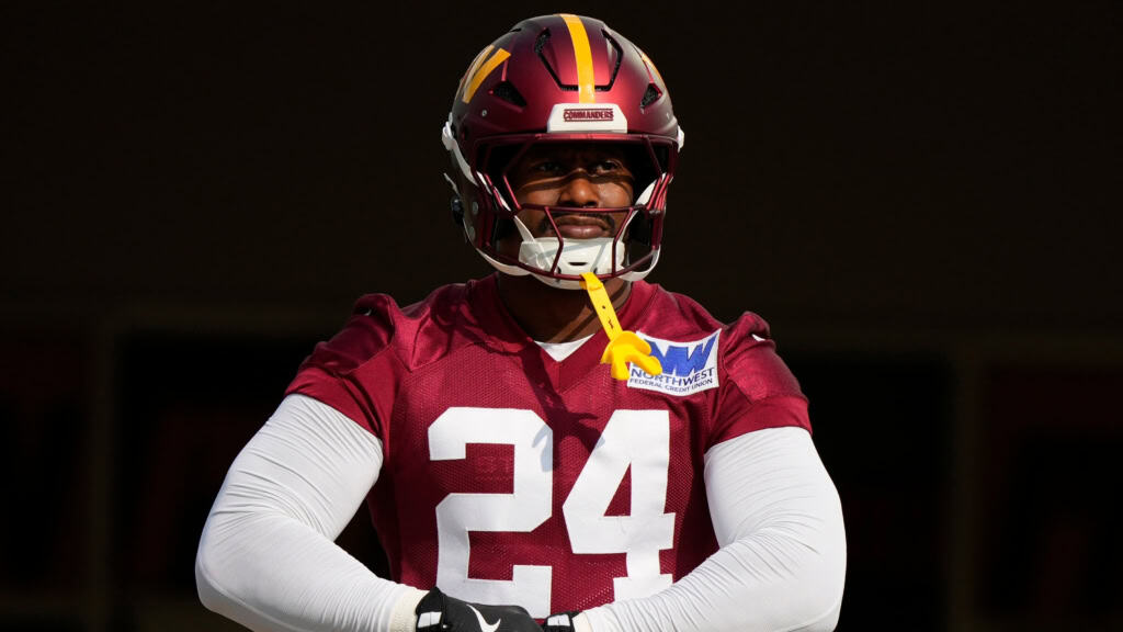 Von Miller stands in a Washington Commanders No. 24 practice jersey with his arms crossed during training camp.