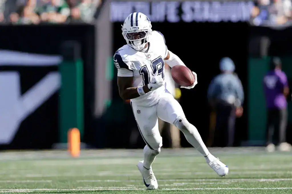 Dallas Cowboys wide receiver Ryan Flournoy runs with the football in a white uniform during an NFL game.