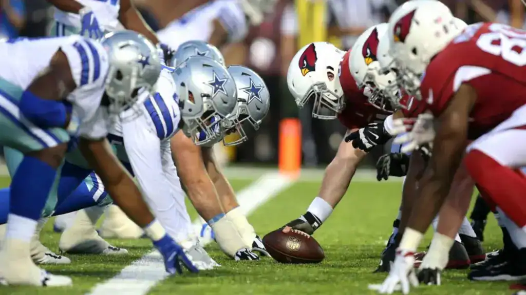 Dallas Cowboys offensive linemen line up against the Arizona Cardinals defense during a preseason game.