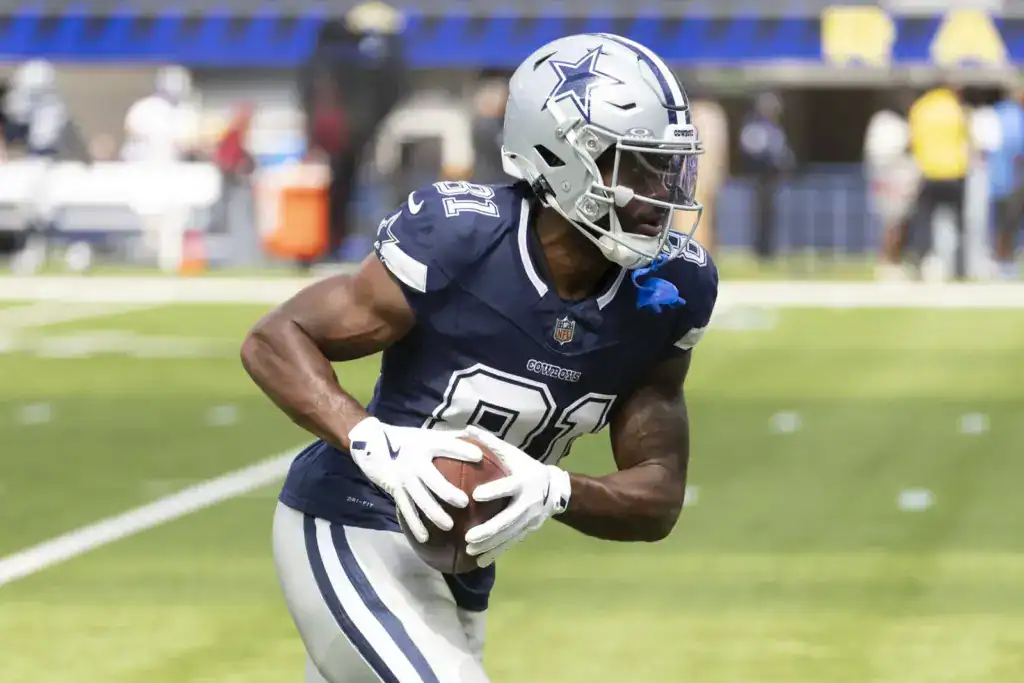 Dallas Pass Catchers Make Their Case in Preseason Game 1 Jonathan Mingo secures the football while running upfield during a Dallas Cowboys game.