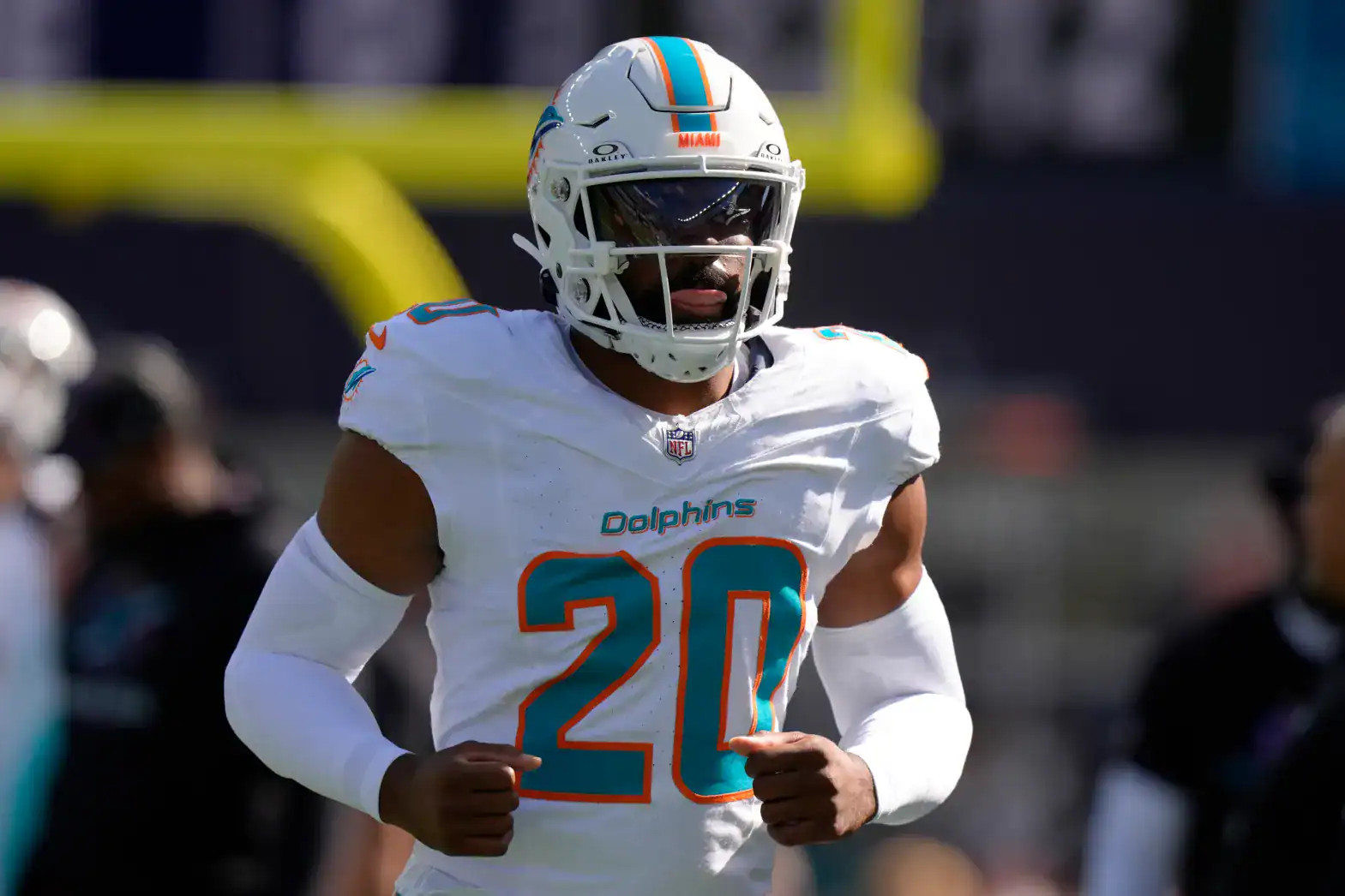 Jordyn Brooks jogs onto the field wearing the Miami Dolphins’ white No. 20 uniform.