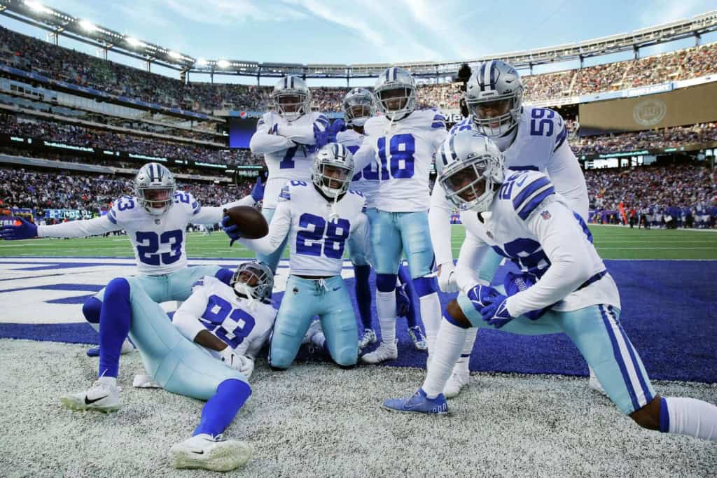 Dallas Cowboys defensive players posing in the end zone after a big play. 
